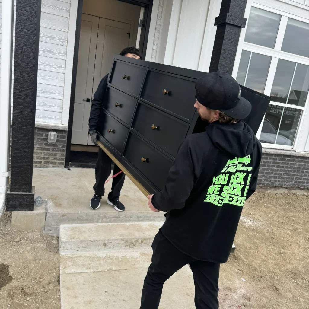 10 Men Movers team completing a last minute moving request by safely loading a large dresser into a home in Nebraska
