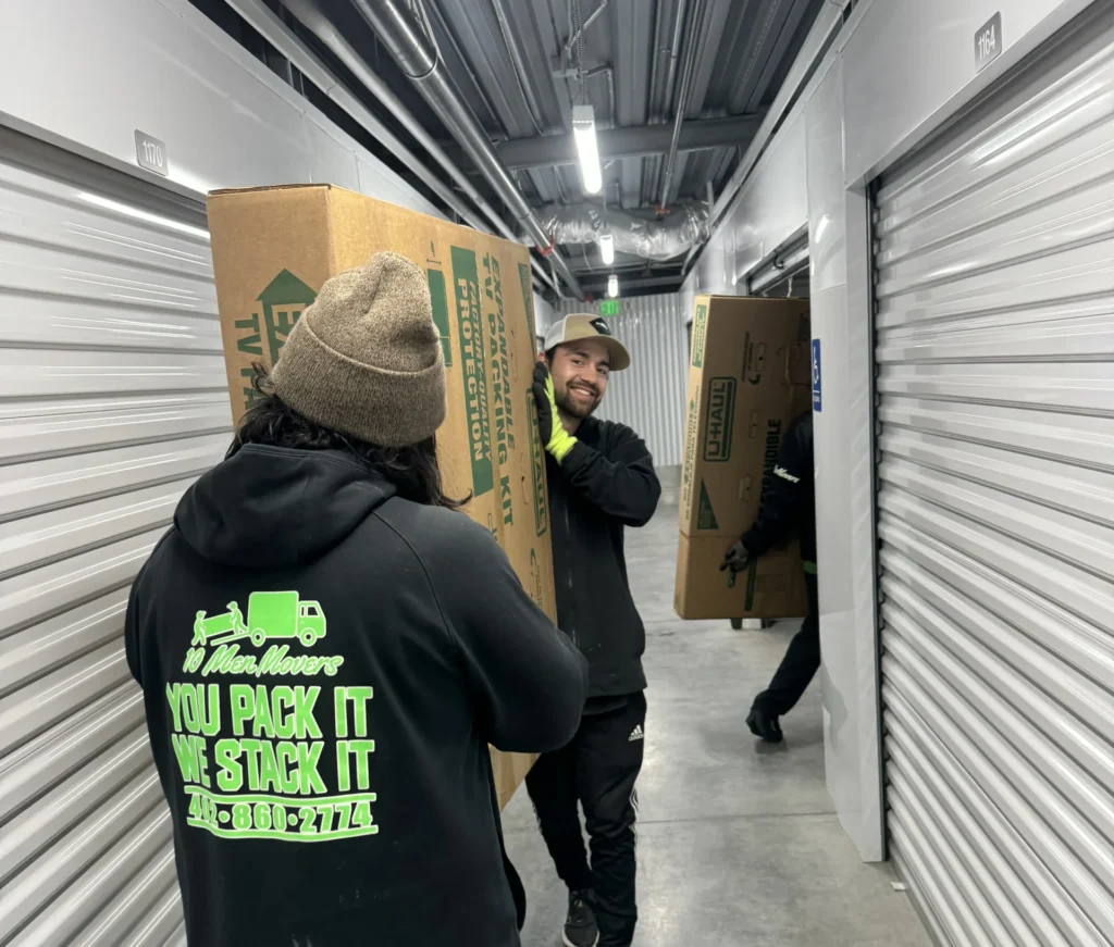 10 Men Movers crew placing boxes into a secure indoor storage unit — providing professional, hassle-free storage in Omaha for moving clients.