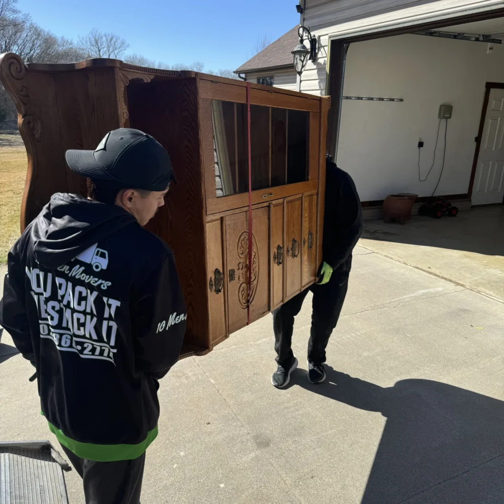 Last minute moving help from 10 Men Movers carrying a large antique hutch for a client near Omaha