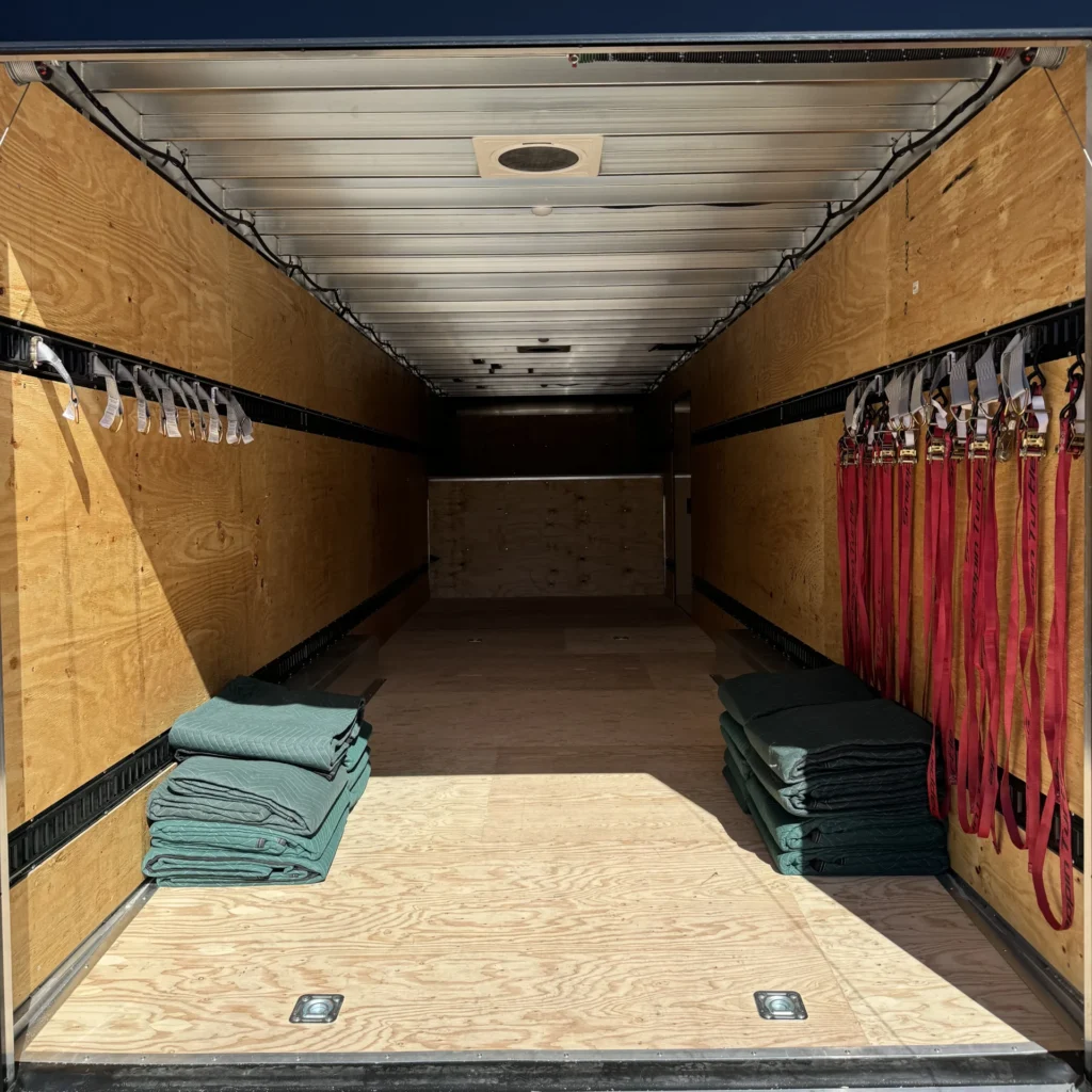 Interior of a moving truck with stacked moving blankets and secured straps, illustrating 10 Men Movers' full-service long-distance moving capabilities.