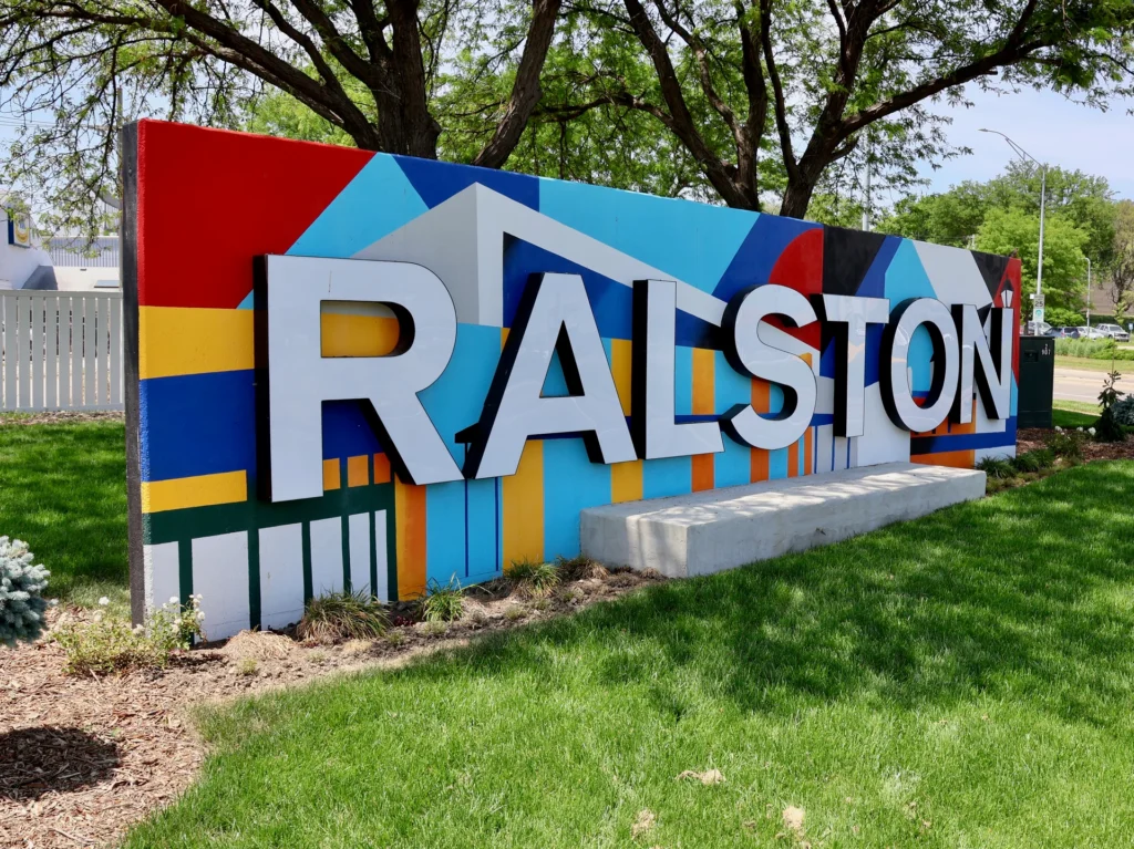 Colorful Ralston sign featuring bold letters against a vibrant mural, symbolizing the community's identity and welcoming new residents.